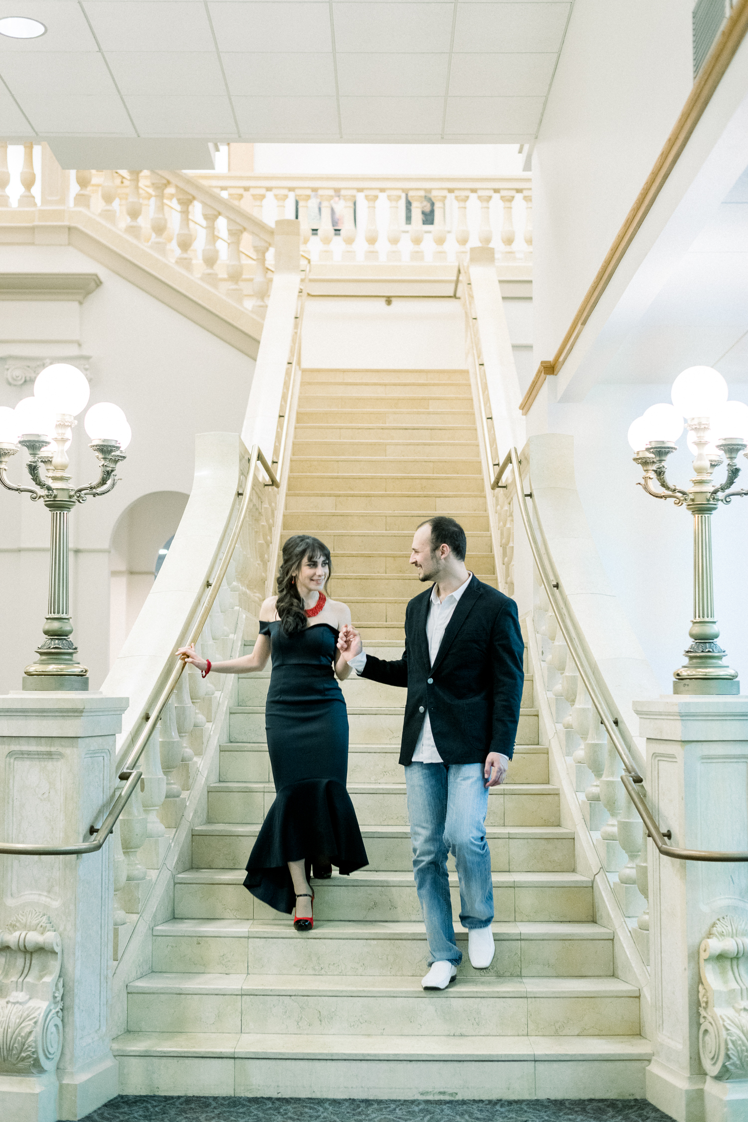 Engaged couple in matching formal black dress and jacket in Milwaukee Library