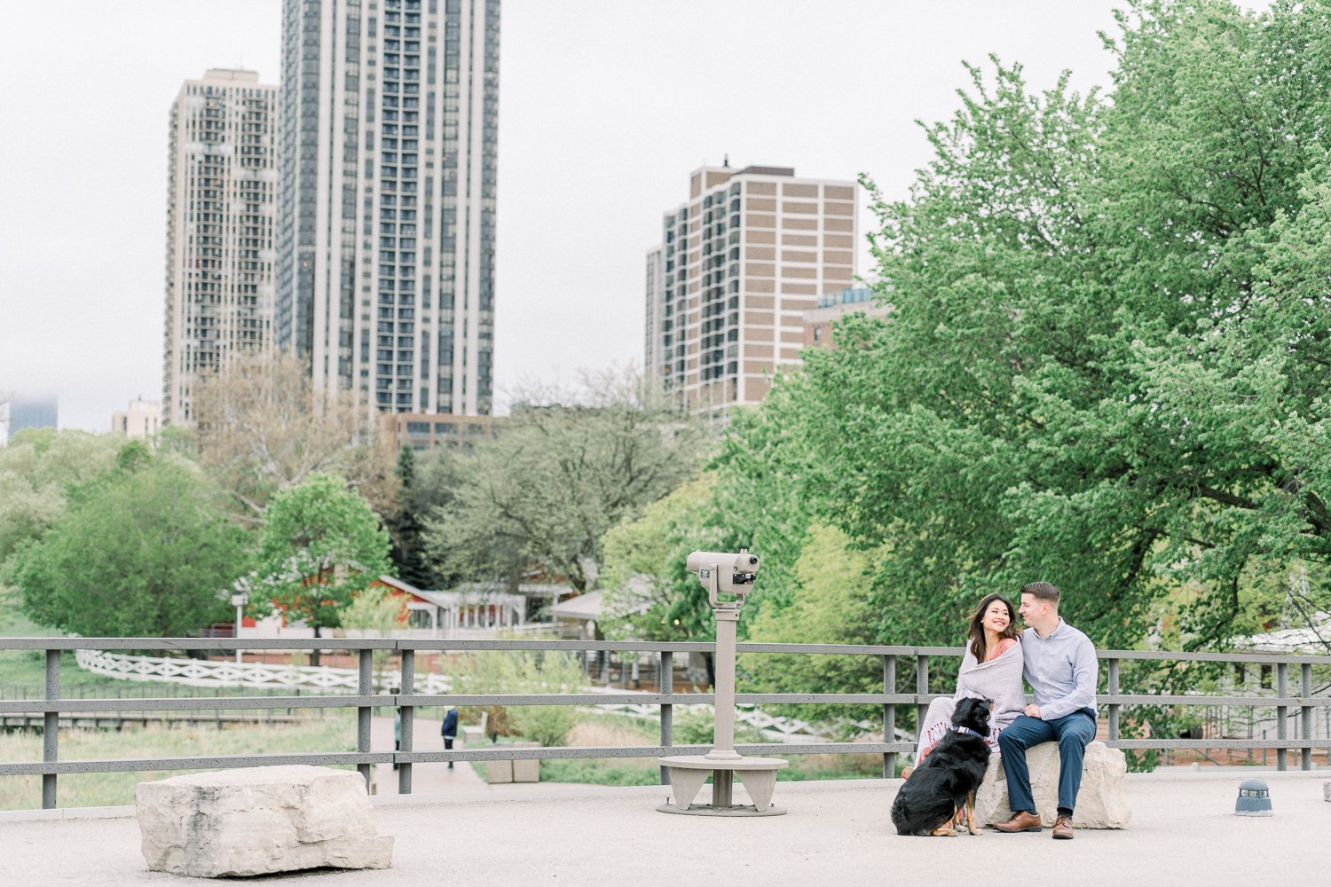 Engaged couple with a black dog on Lincoln Park South Bridge with Chicago Skyline in background