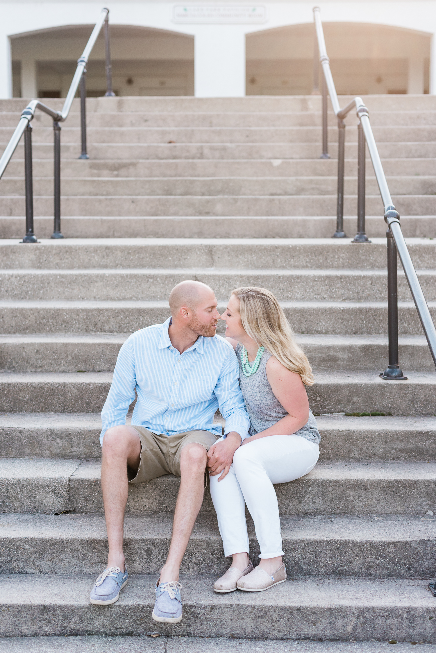 Engaged couple sits on stairs by Lake Park in Milwaukee