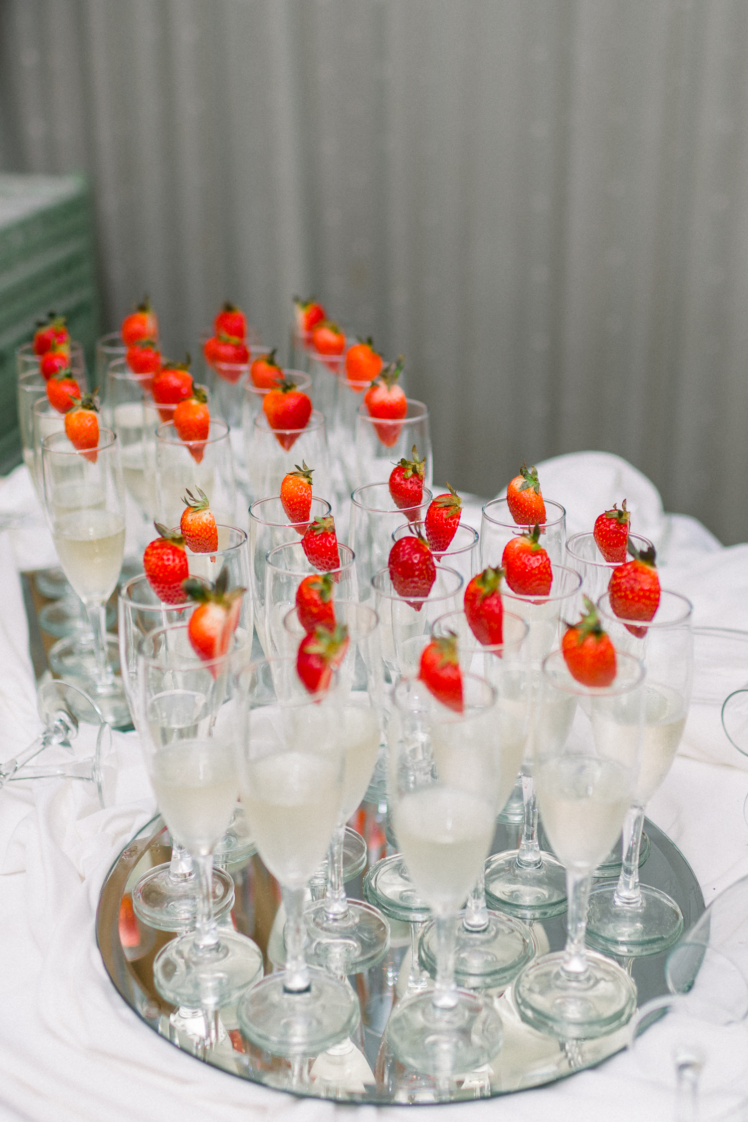 Tray of champagne garnished with cut strawberries