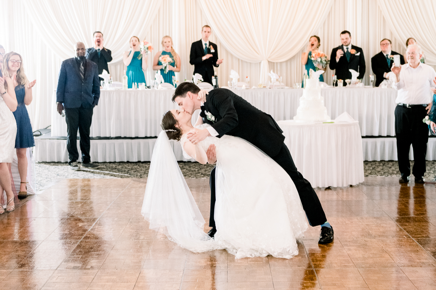 Groom dips his bride on dance floor and kiss