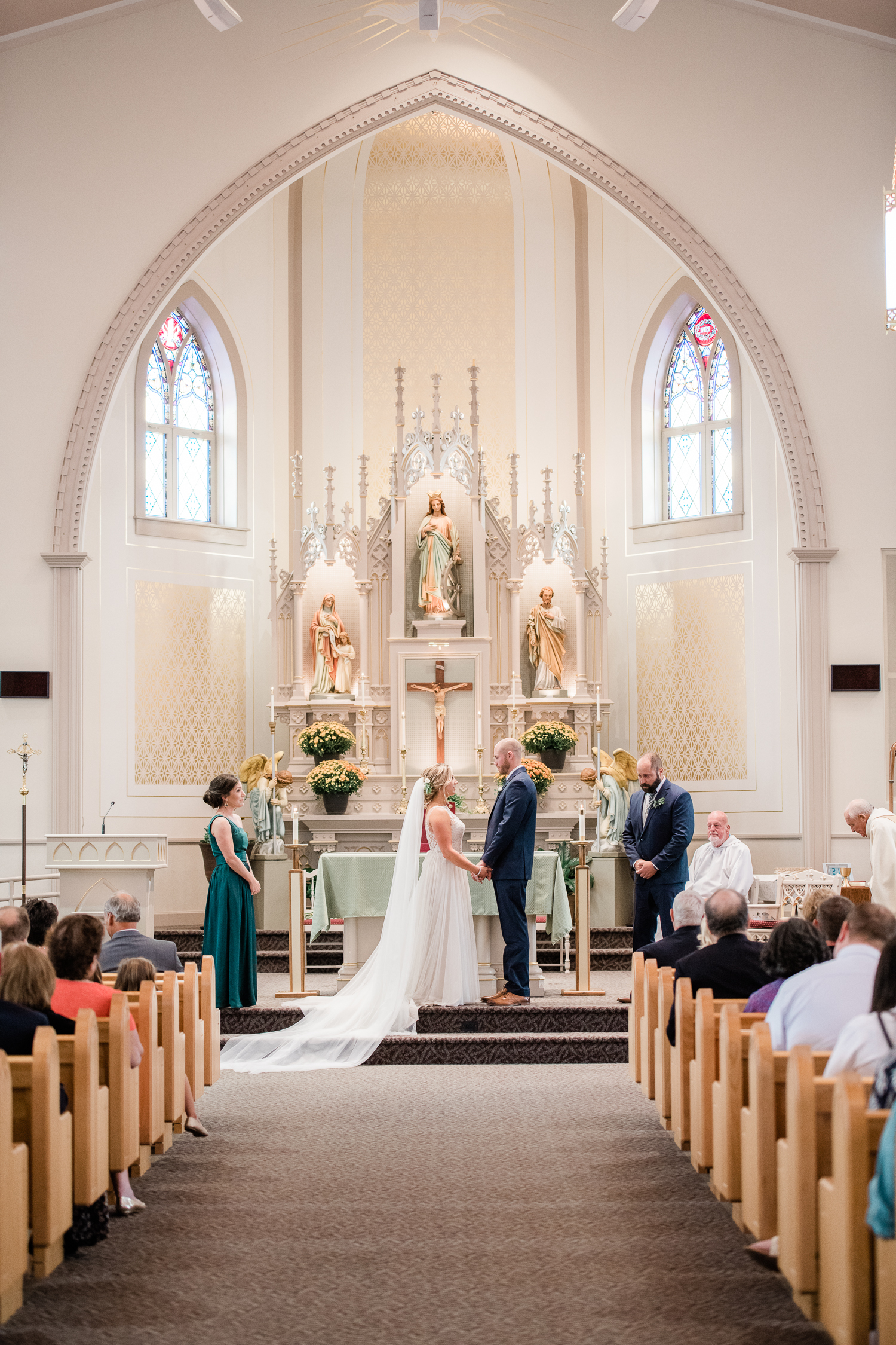 Bride and groom holds hands as they get married at the church altar