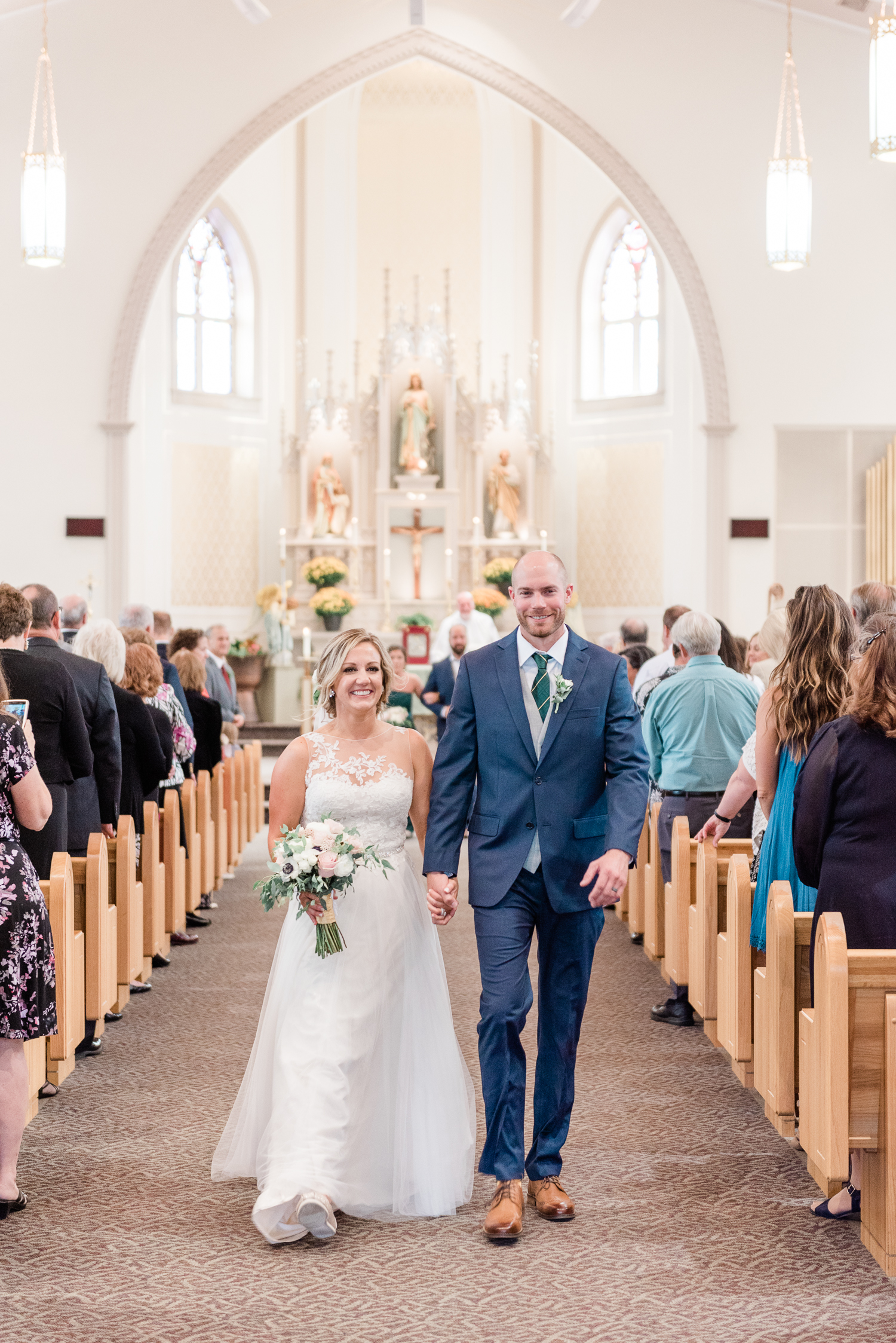 Newly married couple walks down the church aisle