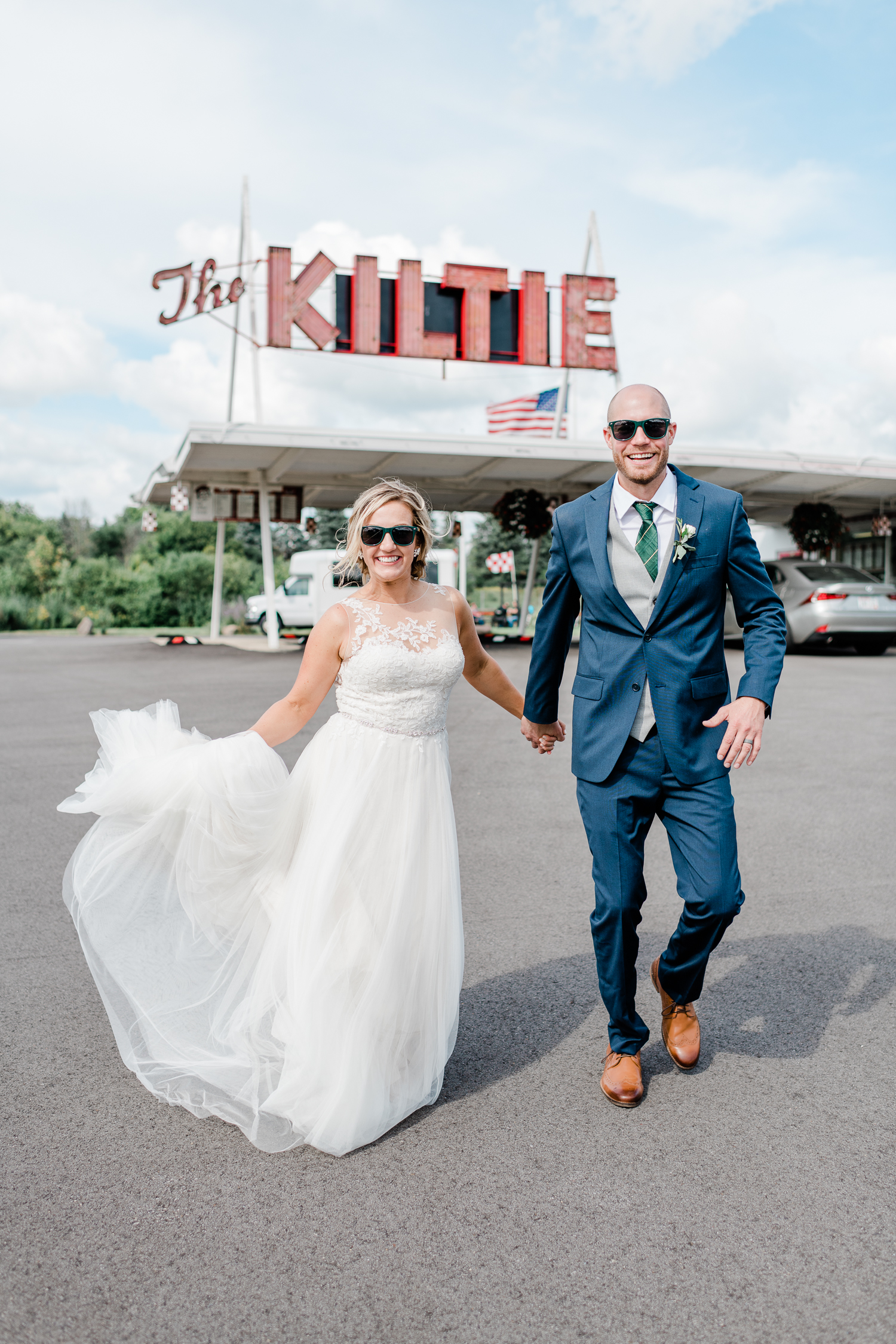 Newly married couple in wedding attire walking at the Kiltie