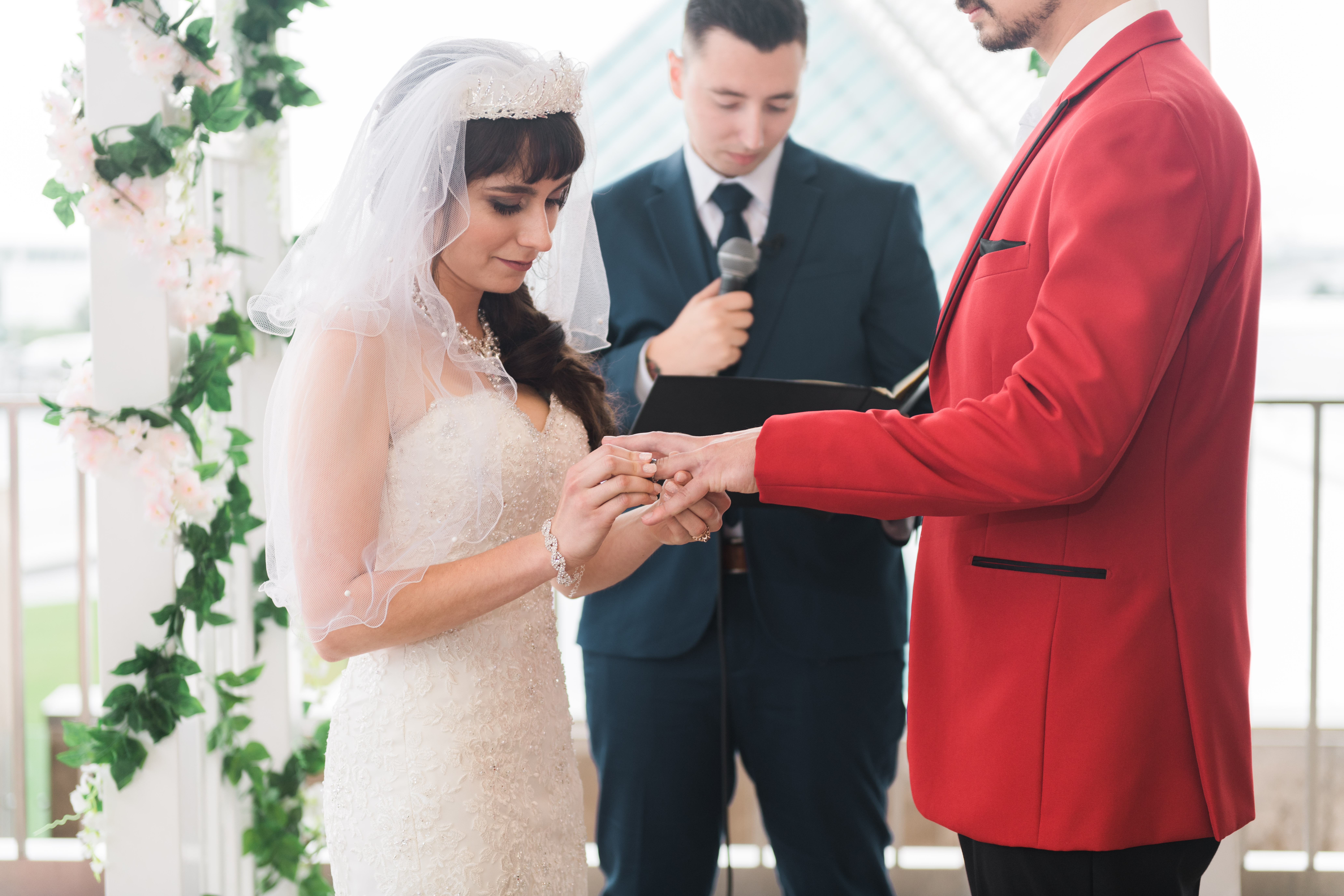 Bride putting on groom's wedding ring during ceremony