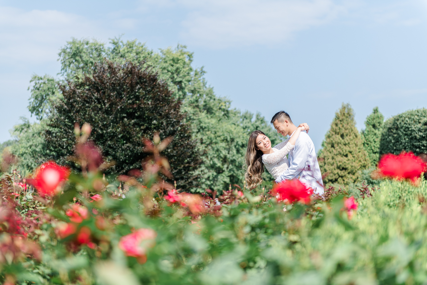 Boy dips girl as she looks into the camera smiling at Chicago Botanic Garden