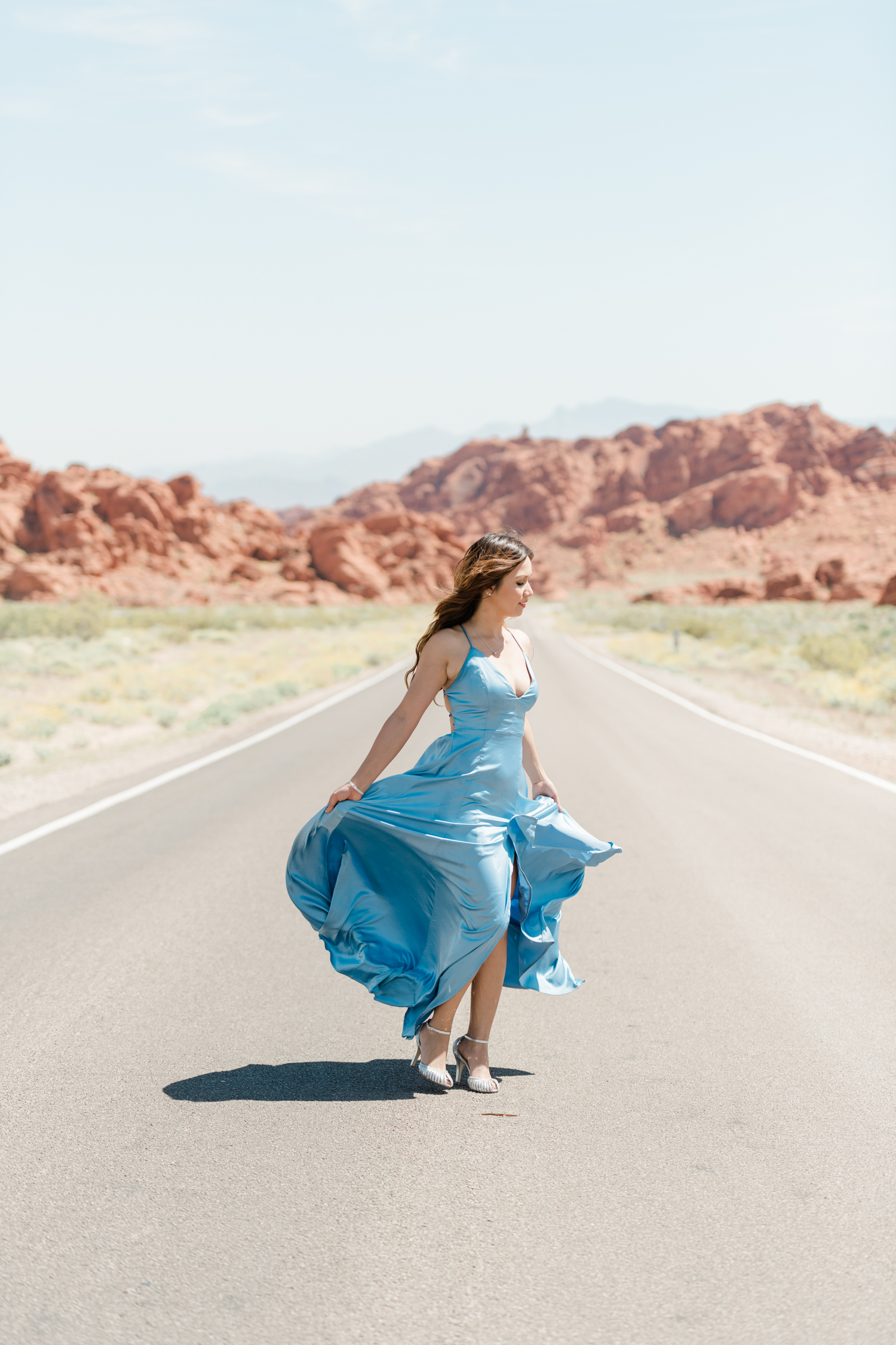 Girl show off blue dress in the middle of the road for Las Vegas Engagement