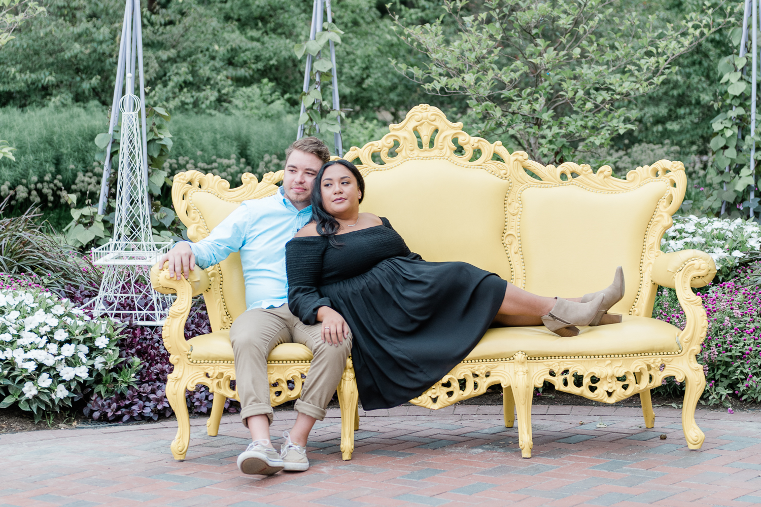 Engaged couple sitting on a yellow couch in Catigny Park