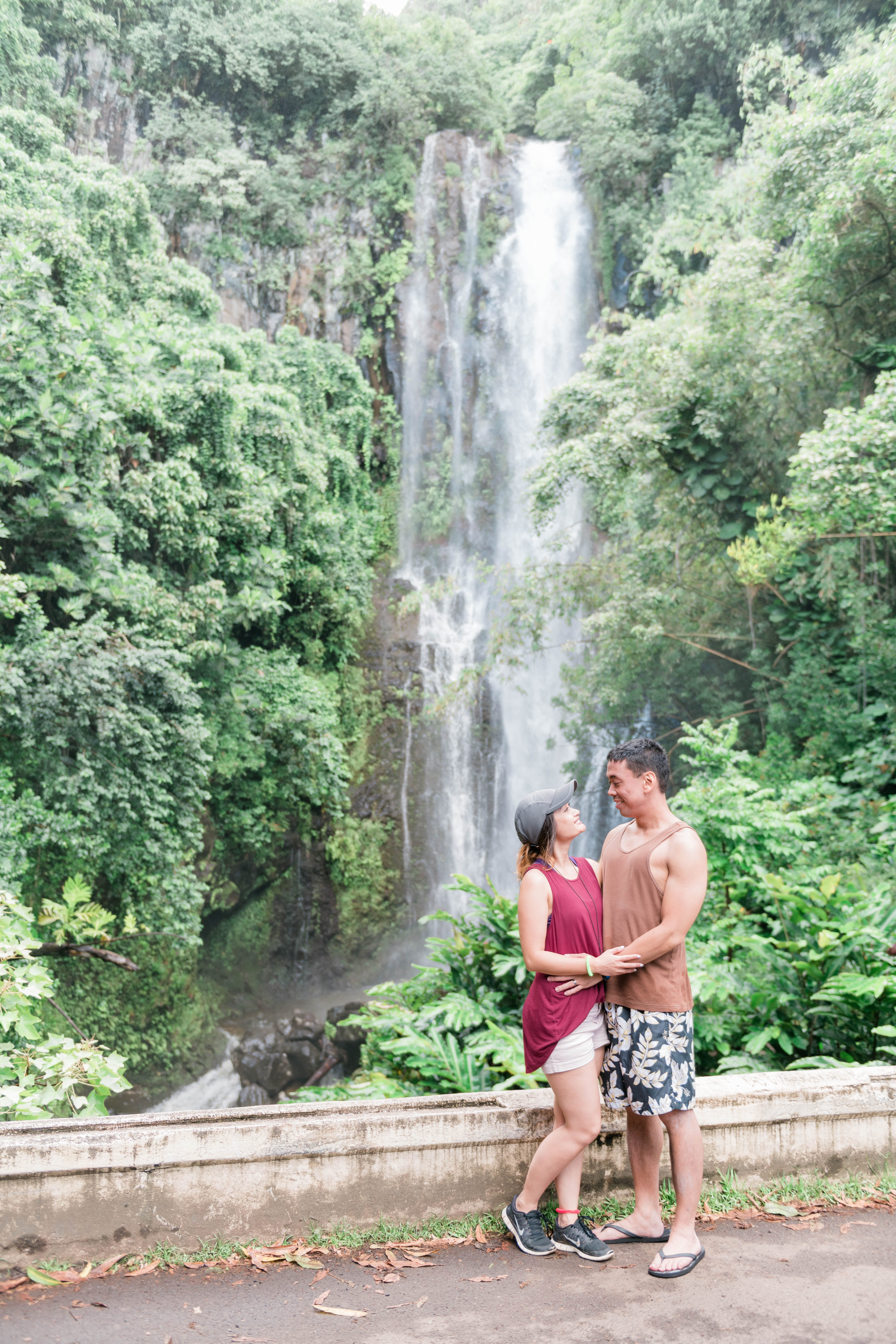 couple looking at each other in front of waterfall during a Maui Engagement Session