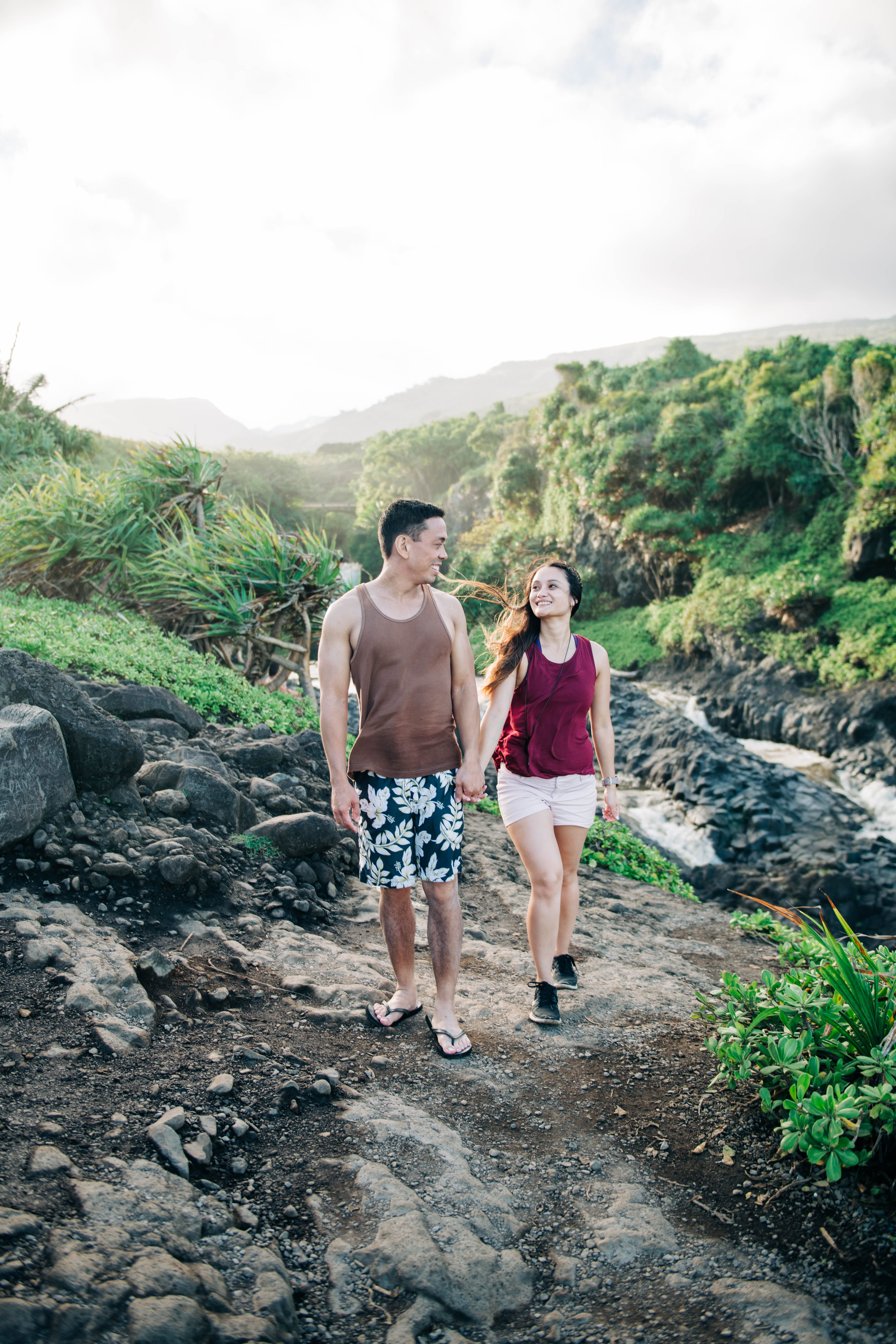 couple holding hands while hiking in the mountain during a Maui Engagement Session