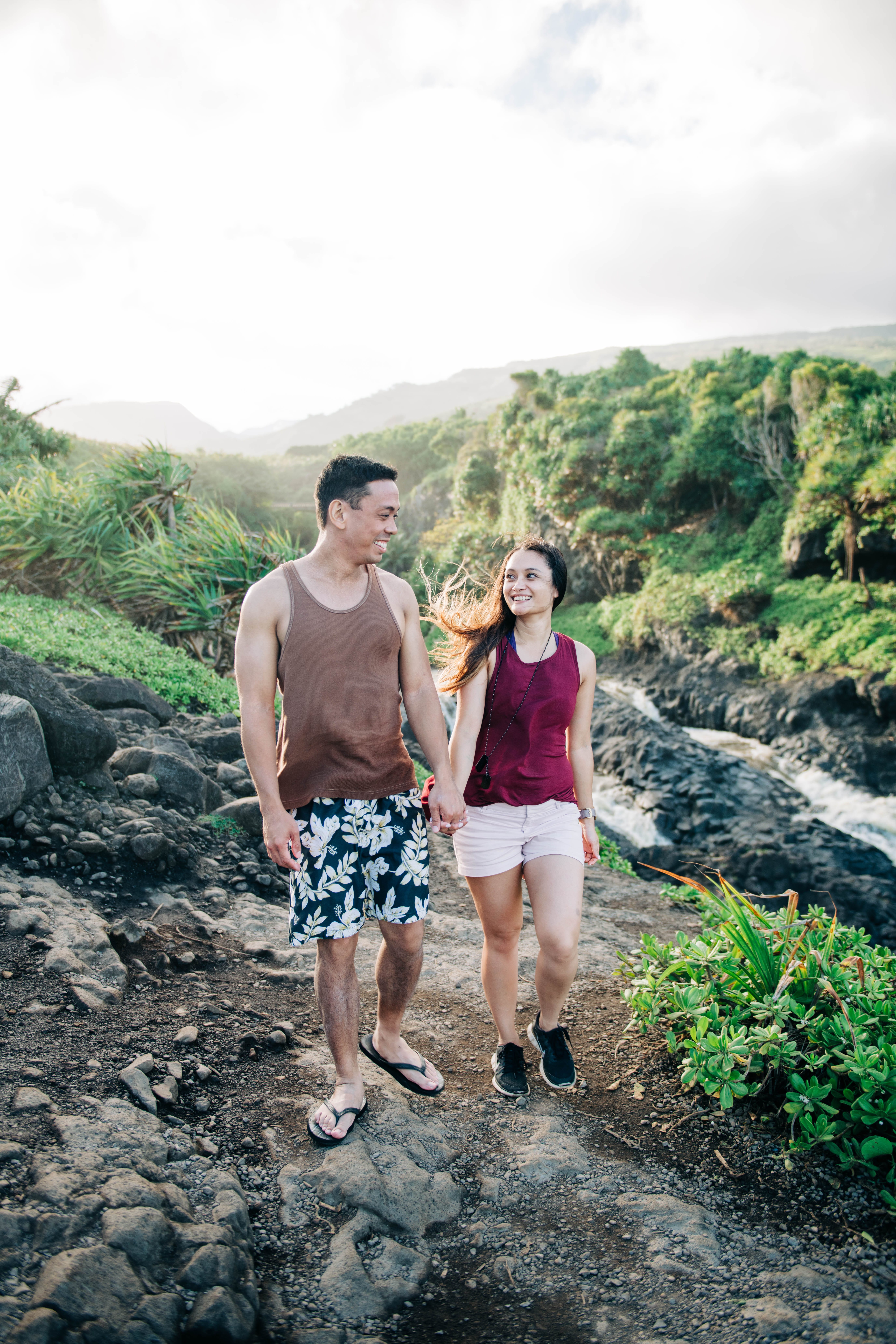couple holding hands while hiking in the mountain during a Maui Engagement Session
