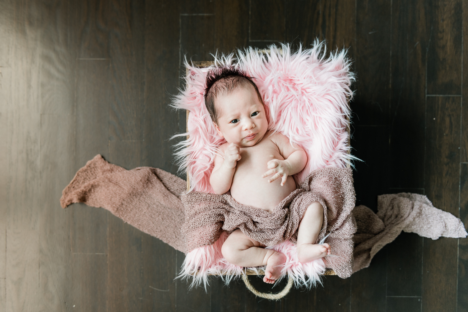 newborn baby girl in a pink basket