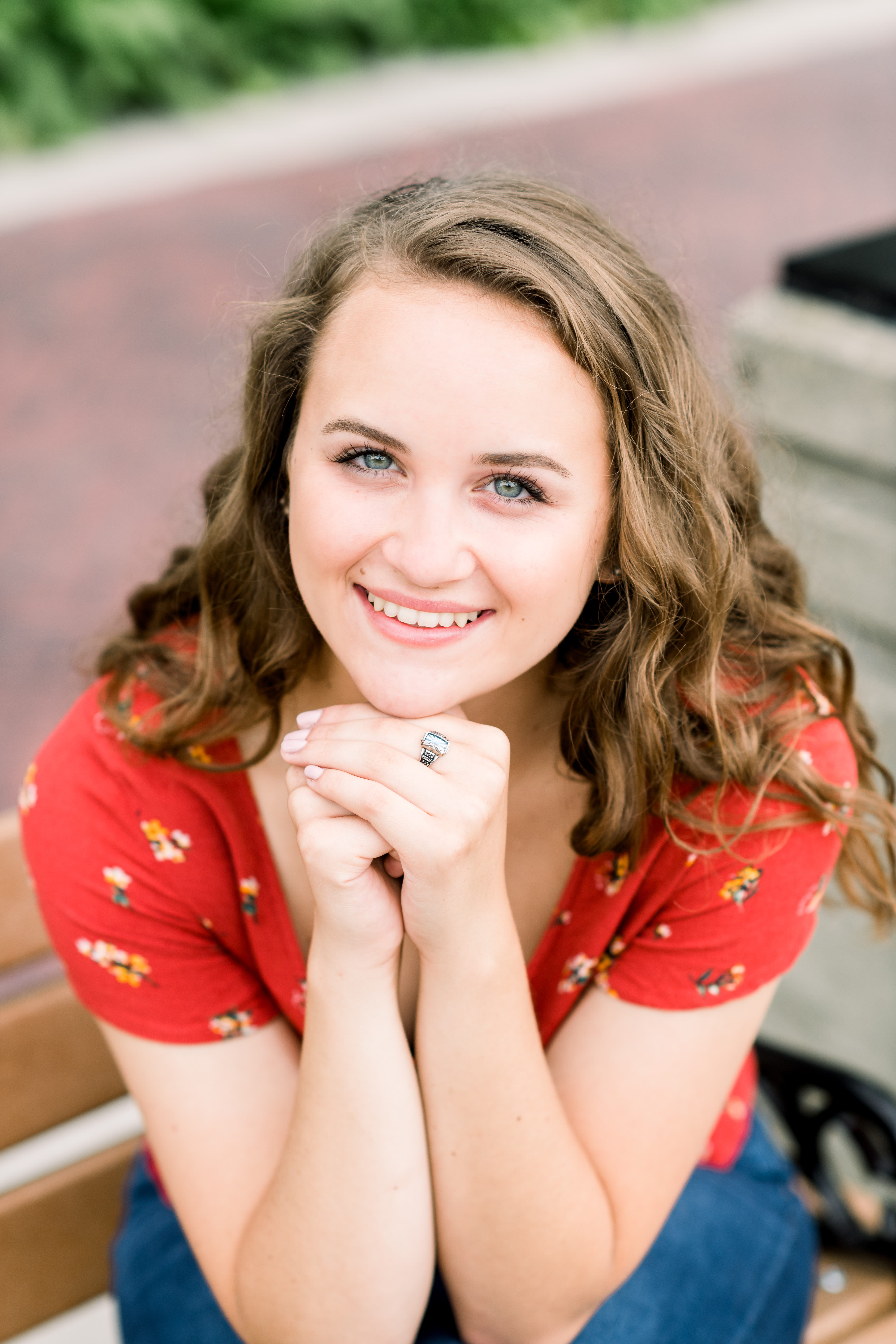 Girl in a red floral top with graduation ring on during her Frame Park Senior Session