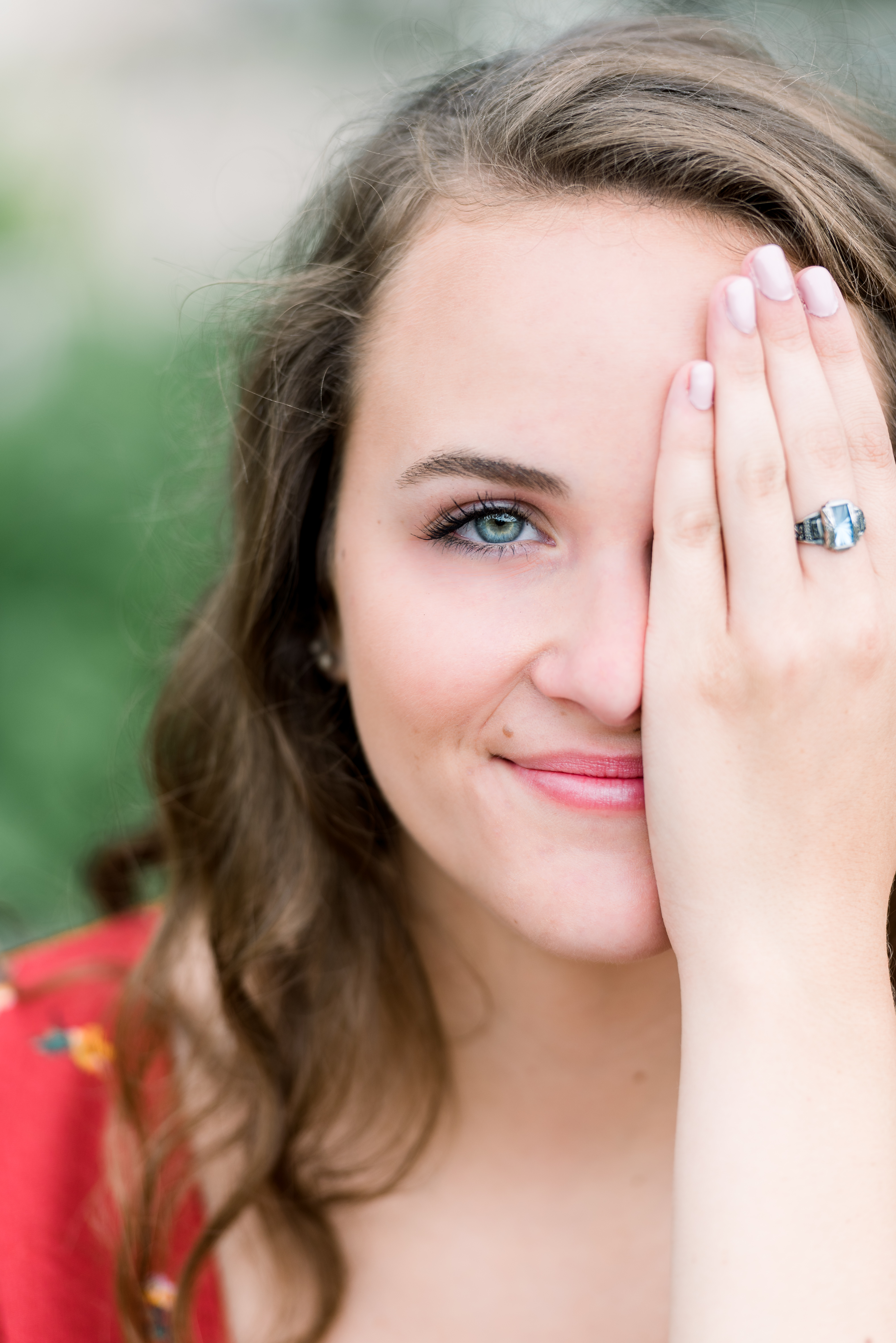 Girl with blue eyes showing off her graduation ring