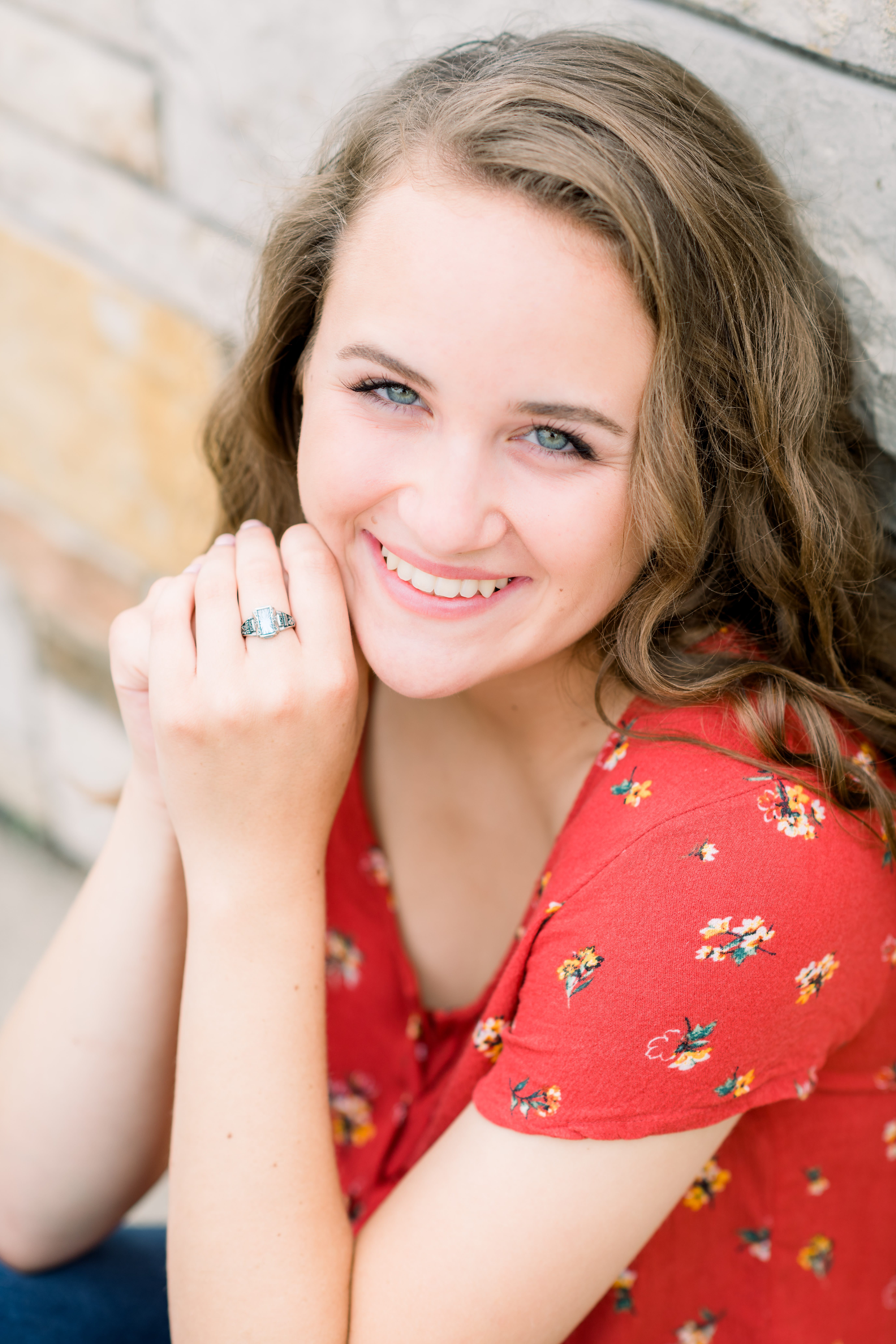 Girl in a red floral top posing for her senior session
