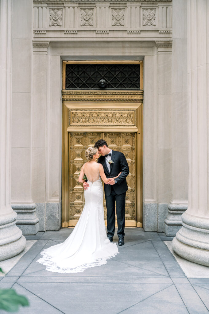 Couple wearing wedding attire in front of Chicago Board of Trade Building on LaSalle Street downtown