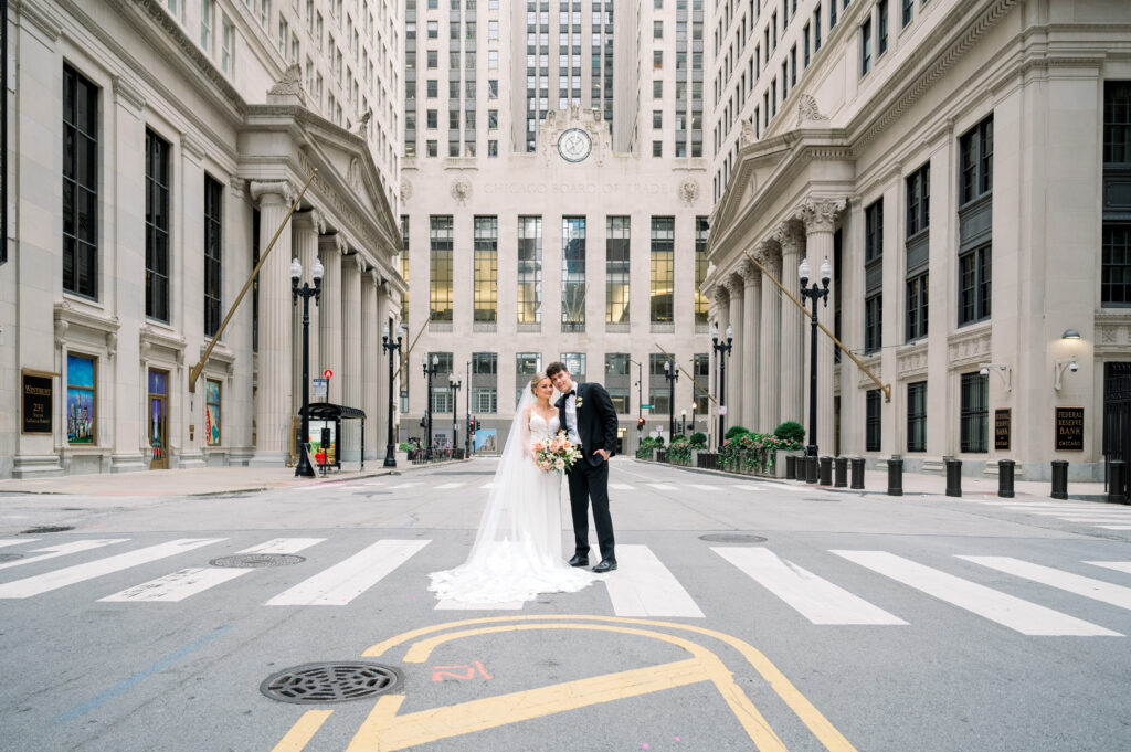 Couple wearing wedding attire in front of Chicago Board of Trade Building on LaSalle Street downtown