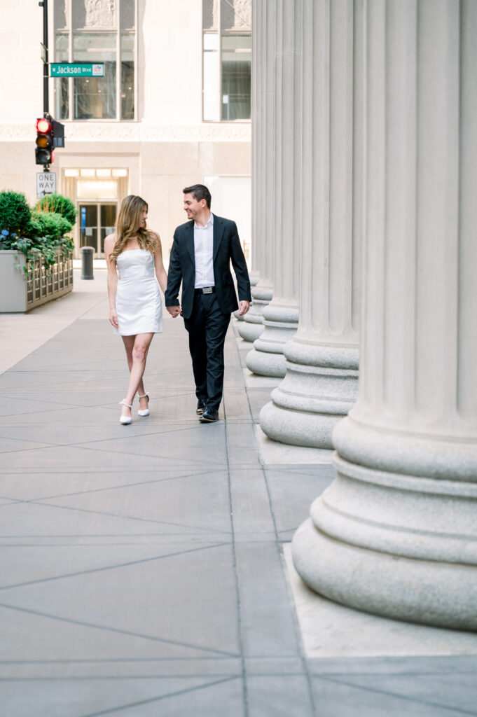 Couple walking on the sidewalk in front of Chicago Board of Trade Building on LaSalle Street downtown