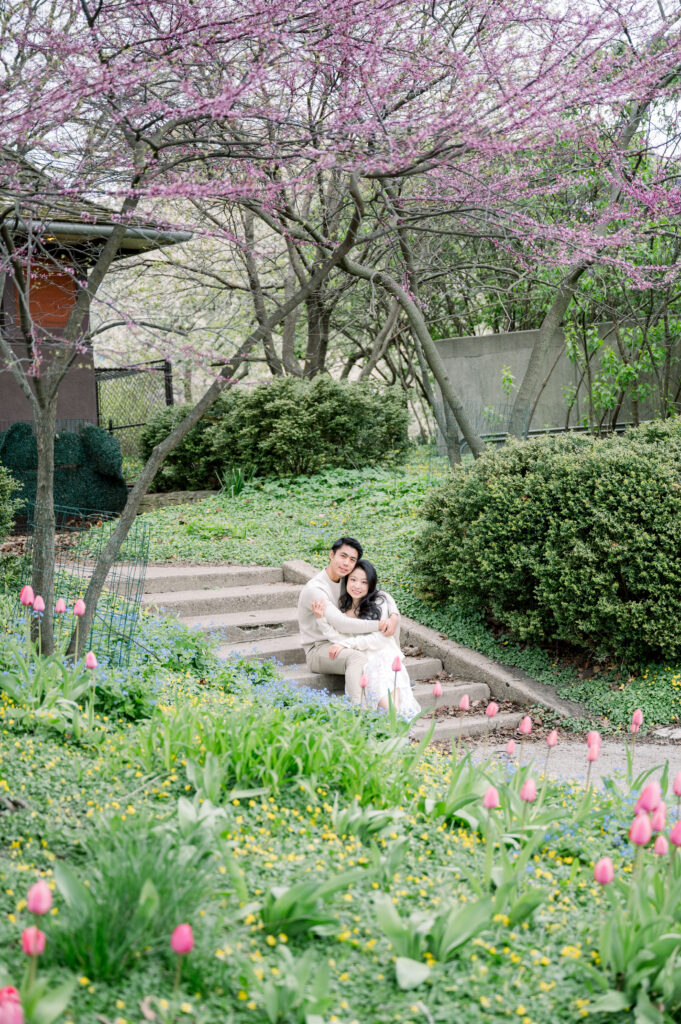 Couple sitting on the steps at Nature boardwalk at Lincoln Park Chicago with skyline view