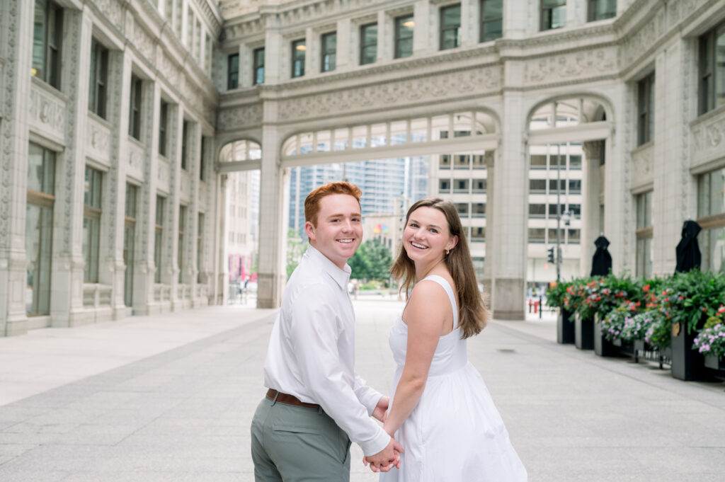 Couple posing in front of Wrigley Building architecture
